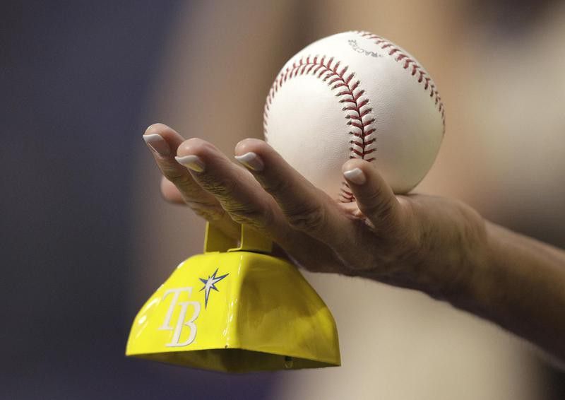 Tampa Bay Rays fan holds a baseball and cowbell