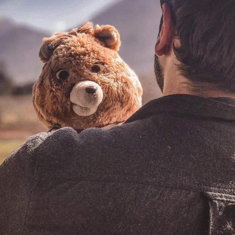 Teddy Ruxpin being held by man