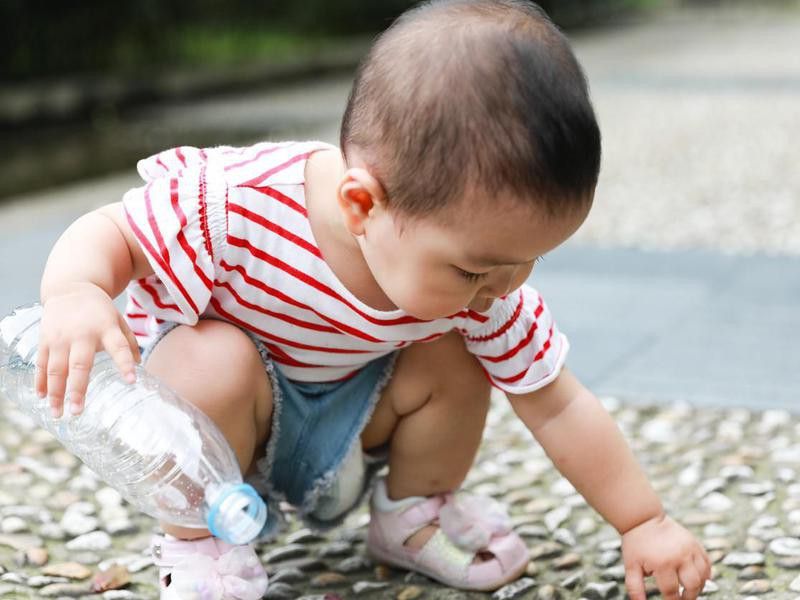 Toddler playing a plastic bottle