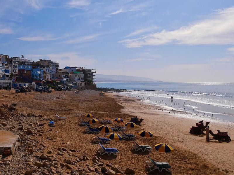 View of the beautiful beach of fishing village Taghazout, a popular surfing spot and tourist destination, on the coast of the Atlantic Ocean.