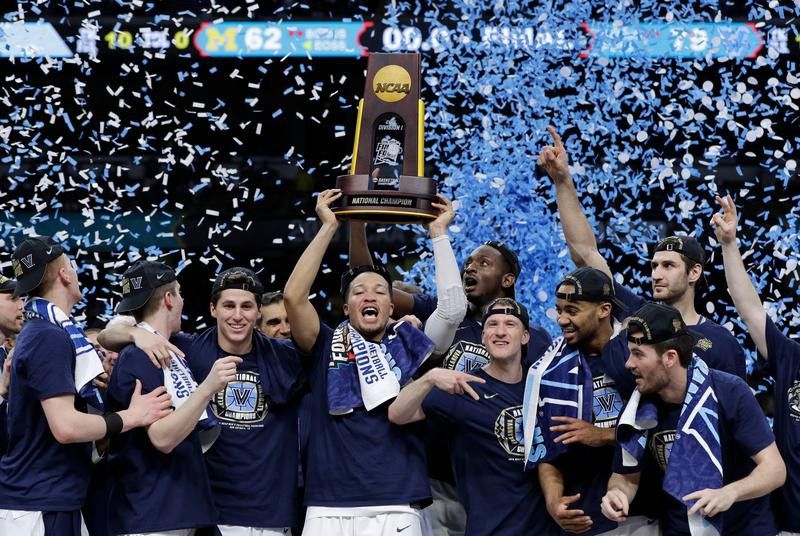 Villanova players celebrate with the trophy after beating Michigan
