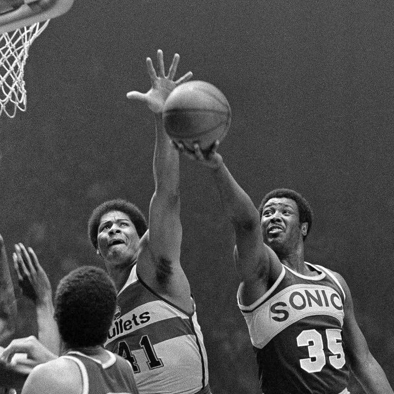 Washington Bullets' Wes Unseld reaches to block shot by Seattle Supersonics' Paul Silas