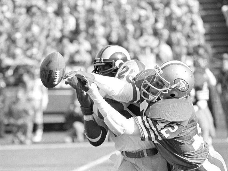 Wendell Tyler and Ronnie Lott go for ball