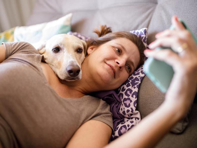 Woman and dog watching videos on phone