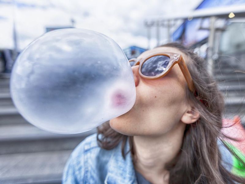 Woman blowing a bubble chewing gum
