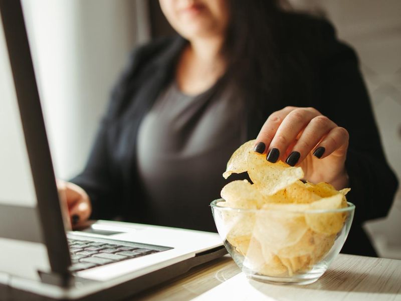Woman eating junk food, snacking with chips