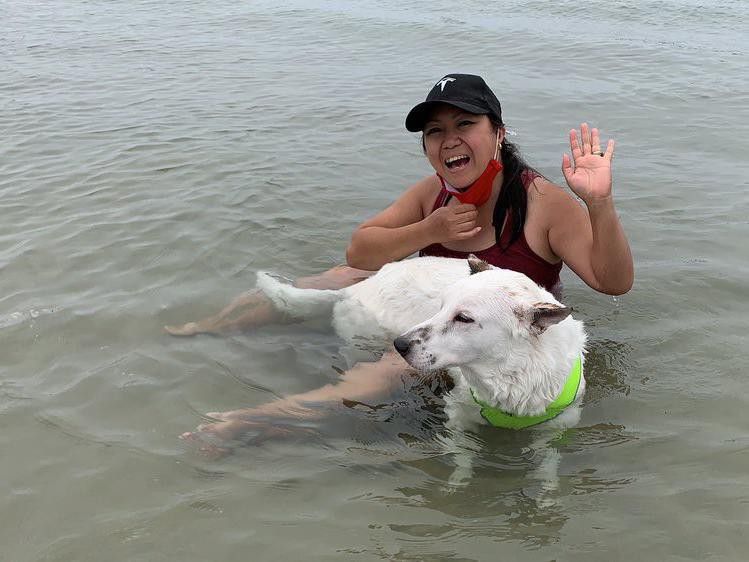 Woman playing in the water with her dog