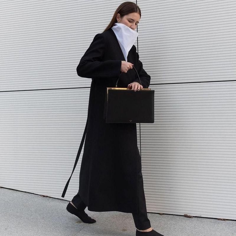 Woman walking in long black jacket