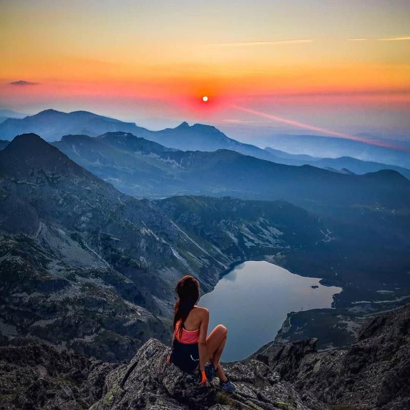 Woman watching the sunrise over Tatra National Park