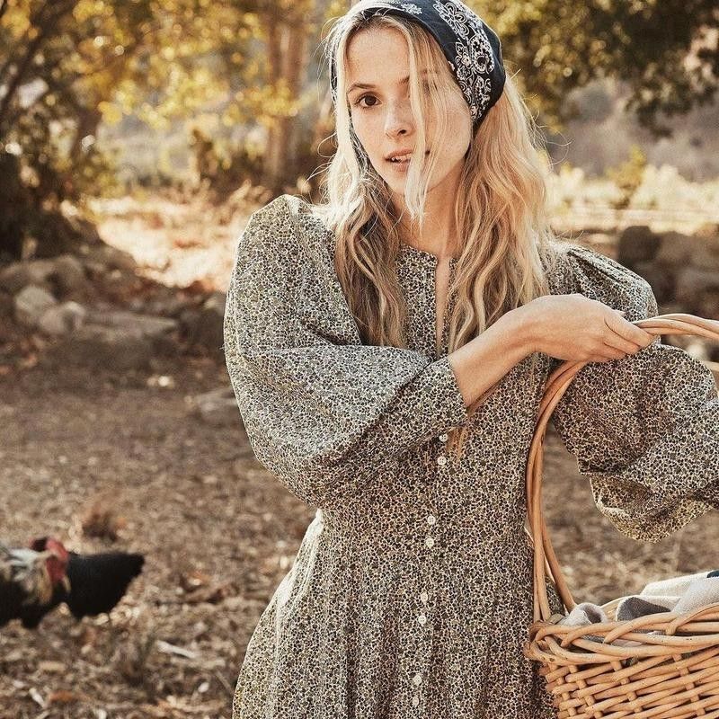 Woman wearing dress in field with basket