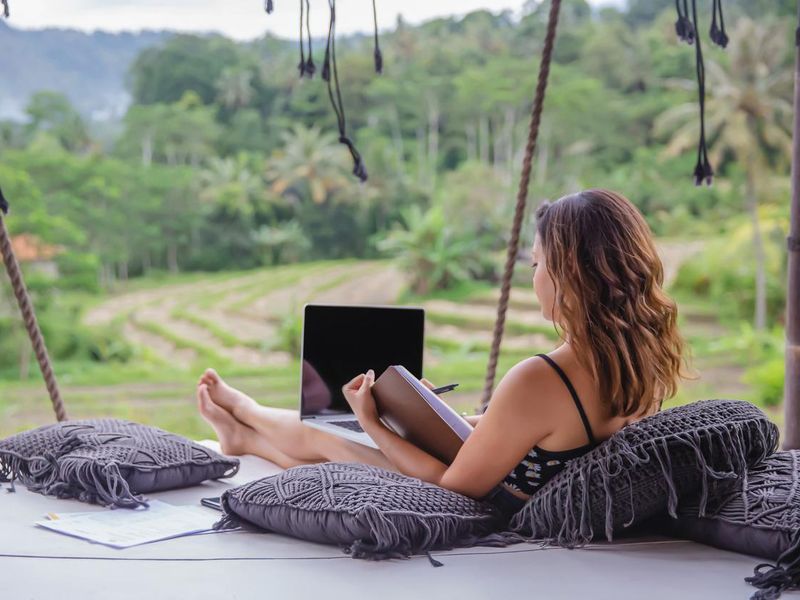 Woman working from private terrace in Bali