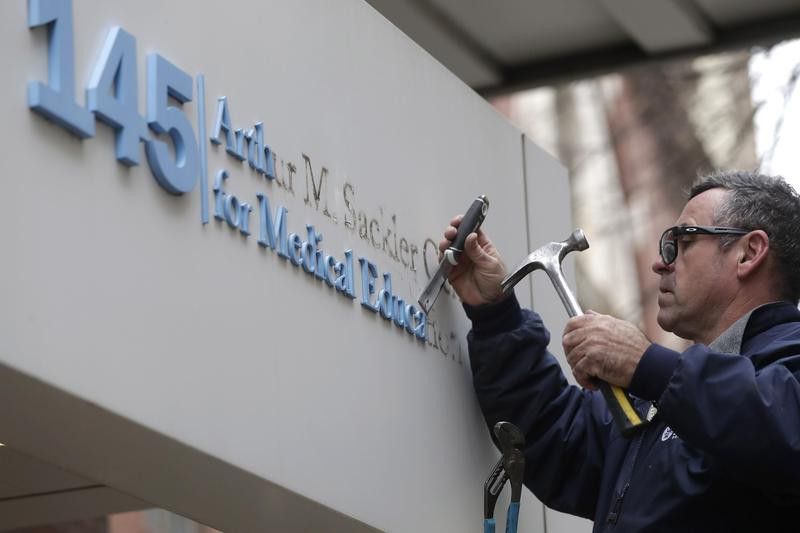 Worker removes "Sackler" name from Tufts School of Medicine entrance